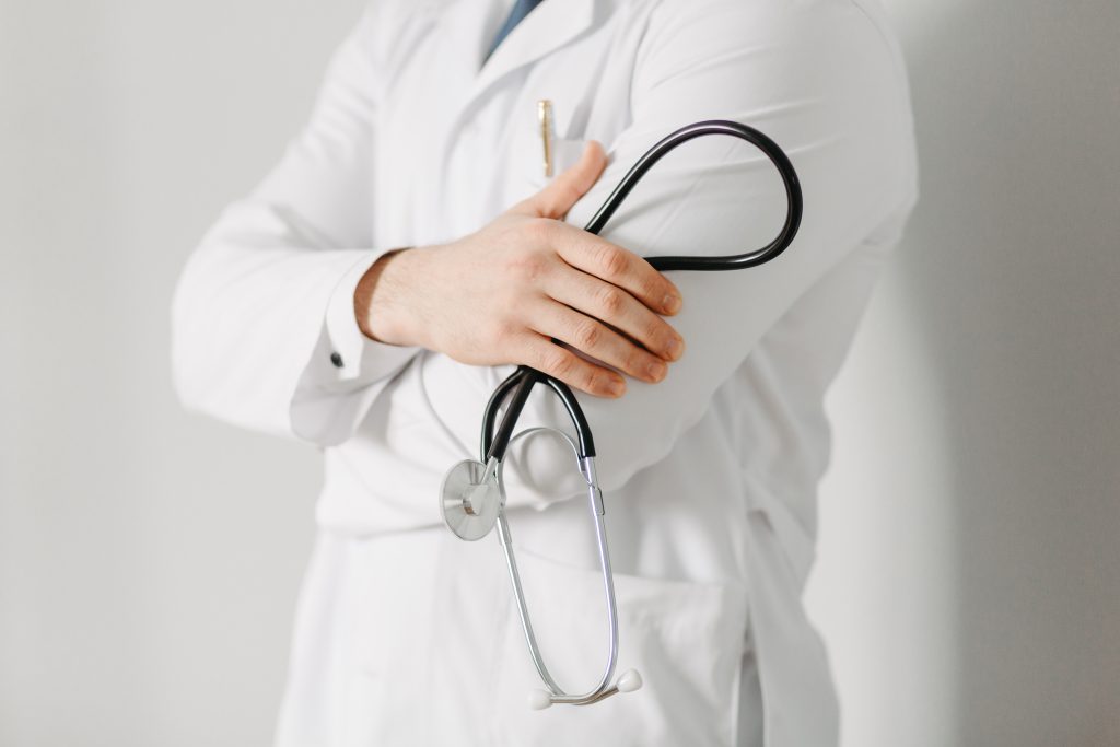 Portrait of a friendly doctor. Isolated on gray Newton Offices